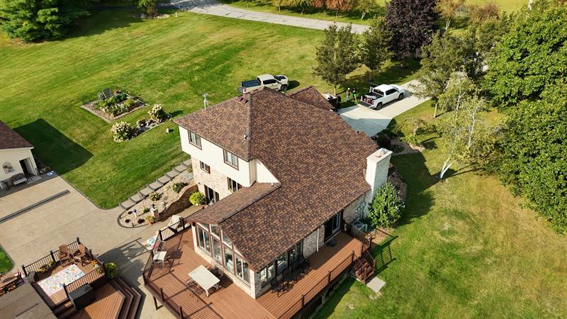 Rural two-story home with a brown roof