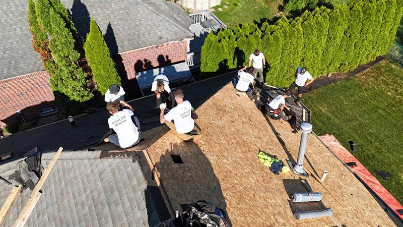 Roofcom crew installing underlayment on new decking